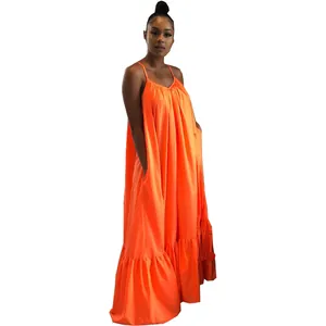 Detail view of vibrant orange sleeveless maxi camisole dress with ruffled hem and pockets