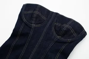 Detailed macro shot of dark blue denim corset top featuring contrast orange topstitching