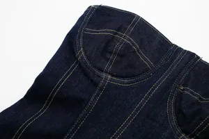 Macro detail view of dark blue denim midi dress featuring yellow contrast topstitching finish