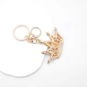 Close-up detail of elegant gold metal crown keychain with sparkling rhinestone accents