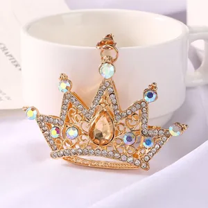 Detailed macro view of a golden crown pendant with multi-colored crystals and rhinestones.