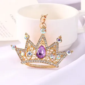 Detailed close-up of a sparkling crystal crown keychain with a purple teardrop gem