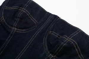 Detail shot of navy denim dress bodice featuring contrast stitching and structure.