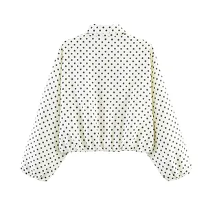 Vista trasera de una chaqueta blanca de lunares con mangas abullonadas y cuello solapa
