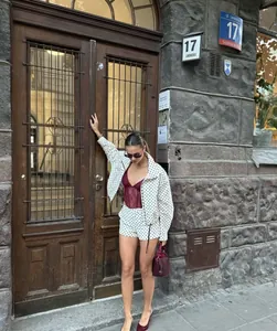 Stylish women's white polka dot seersucker jacket presented in a street fashion lifestyle photo