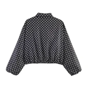 Vista posterior de una elegante chaqueta de lunares negros y blancos con mangas abullonadas