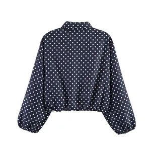 Vista trasera de chaqueta azul marino de lunares con mangas abullonadas y solapa