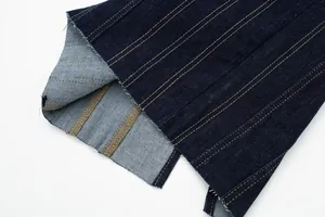 Close-up detail of contrast topstitching and back split hem on navy denim midi dress