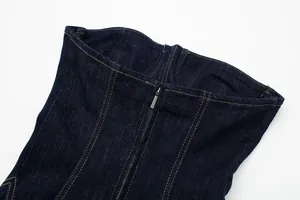 Detail shot of a dark blue denim dress featuring a front zipper and contrast topstitching.