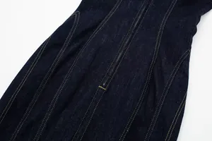 Close-up detail of decorative topstitching on dark blue midi denim dress.