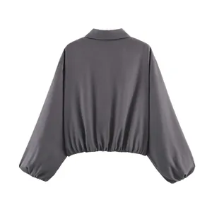 Vista posterior de una chaqueta gris para mujer con cuello de solapa y mangas abullonadas