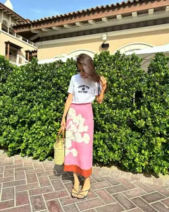 Summer lifestyle detail showing a pink floral linen blend midi skirt with a stylish white tee