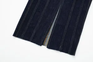 Close-up of contrast stitching and raw hem slit detail on denim midi dress