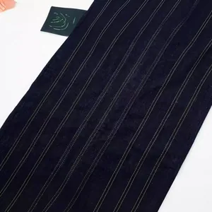 Close-up of dark blue denim midi dress with decorative yellow topstitching pattern