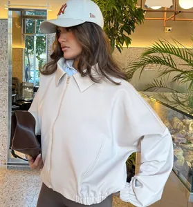Detalle de una elegante chaqueta de cuero sintético blanco con mangas abullonadas