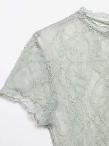 Detailed macro view of light green floral lace short sleeve T-shirt showing texture