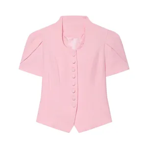 Detail of pink short-sleeved blazer featuring a lace neckline and puff sleeves.