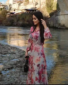 Elegant floral print long-sleeved maxi dress worn by a model in a scenic outdoor setting