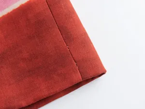 Macro view of the linen blend fabric and stitching on a printed skirt hem detail.