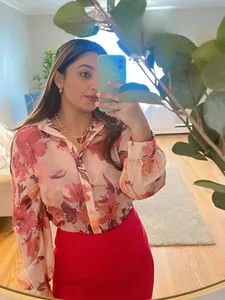 Detailed view of stylish women's pink floral chiffon blouse and red skirt set on model