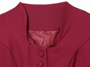 Detail view of burgundy blazer neckline with delicate lace trim and covered buttons