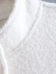 High-resolution macro detail of soft white sherpa fleece texture on a women jacket collar