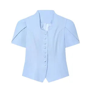 Close-up of a light blue short-sleeved blazer featuring lace collar detail and covered buttons.