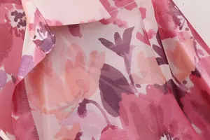 Macro detail of elegant pink floral print fabric with silky texture and fine collar stitching