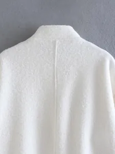 Macro detail of the elegant stand collar and soft textured fabric on this white jacket