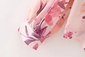 Close-up detail of elegant pink floral print sleeve cuff on chiffon women's dress