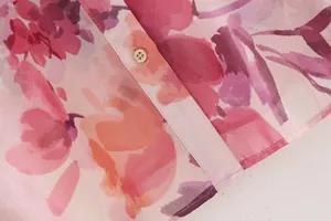 Detailed macro shot of premium pink floral print dress fabric and button closure