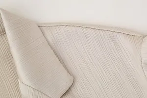 Detailansicht des eleganten champagnerfarbenen Plissee-Blazers mit feiner Stoffstruktur und Kragen.