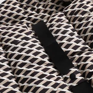 Close-up of geometric pattern and black belt detail on a winter puffer jacket