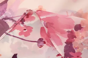 Detail view of lightweight pink floral printed chiffon fabric with soft texture and sheer finish