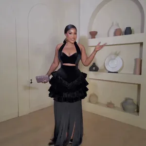 Elegant black velvet halter evening dress with tiered ruffles and long fringe hemline details