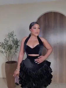 Elegant black velvet halter evening dress featuring a stylish tiered ruffle cake skirt design