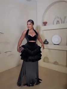 Black velvet halter evening dress with tiered ruffles and elegant fringe hem