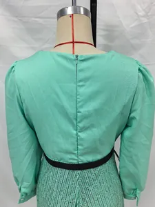 Detailansicht eines eleganten minzgrünen Paillettenkleides mit Puffärmeln und Reißverschluss.
