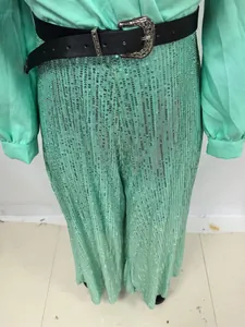 Detaillierte Ansicht einer minzgrünen Pailletten-Hose mit einem stilvollen schwarzen Gürtel