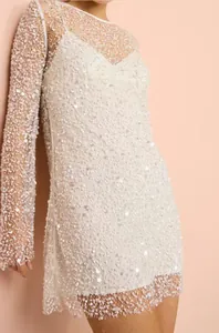 Detailansicht eines eleganten weißen Pailletten-Netzkleids mit passendem Unterkleid