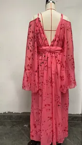Elegante roze zwangerschapsjurk met bloemenprint, diepe V-hals en vleermuismouwen detail.