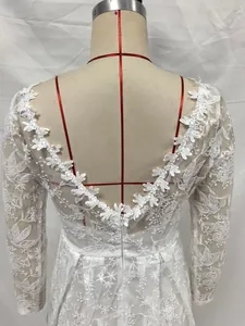 Détail de robe de mariée en dentelle à manches longues avec élégant dos en V et broderie