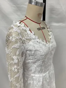 Détail de robe de mariée blanche à manches longues avec broderie florale complexe en dentelle