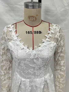 Détail du haut d'une robe de mariée en dentelle florale blanche sur mannequin