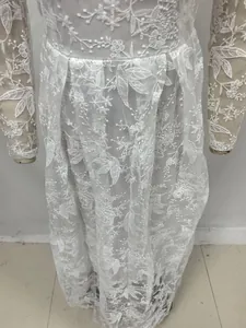 Gros plan détaillé d'une robe de mariée en dentelle blanche aux broderies florales