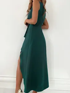 Side profile of an elegant dark green sleeveless maxi dress with a stylish side slit
