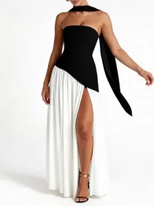 Elegant monochrome strapless evening gown with high slit and flowing scarf detail