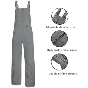 Detailed view of grey waterproof ski bib pants with adjustable straps and metal zipper.