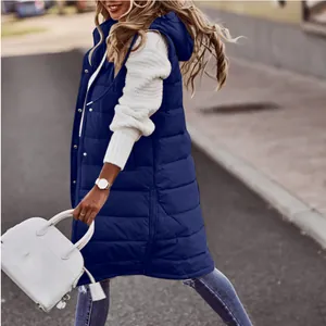 Dettaglio del gilet trapuntato lungo blu navy da donna mostrato in un contesto urbano.