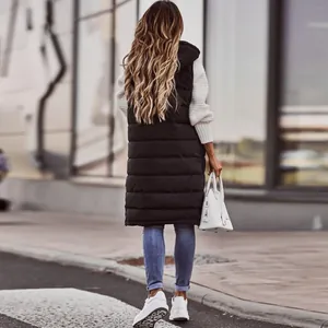 Vista posteriore di una donna con un lungo gilet imbottito nero con cappuccio e maglia